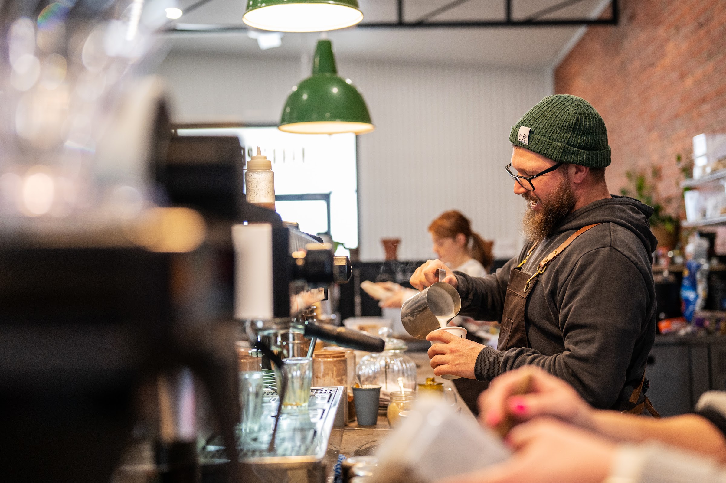 A barista pours milk into a cup at the espresso machine at Harry Pepper Coffee, Deniliquin